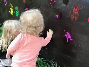 Børn maler på væg